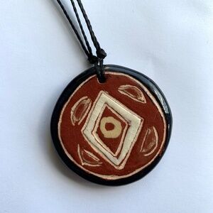 Ceramic pendant necklace in reddish-brown, cream, and black